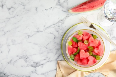 Photo of Delicious salad with watermelon on white marble table, flat lay. Space for text