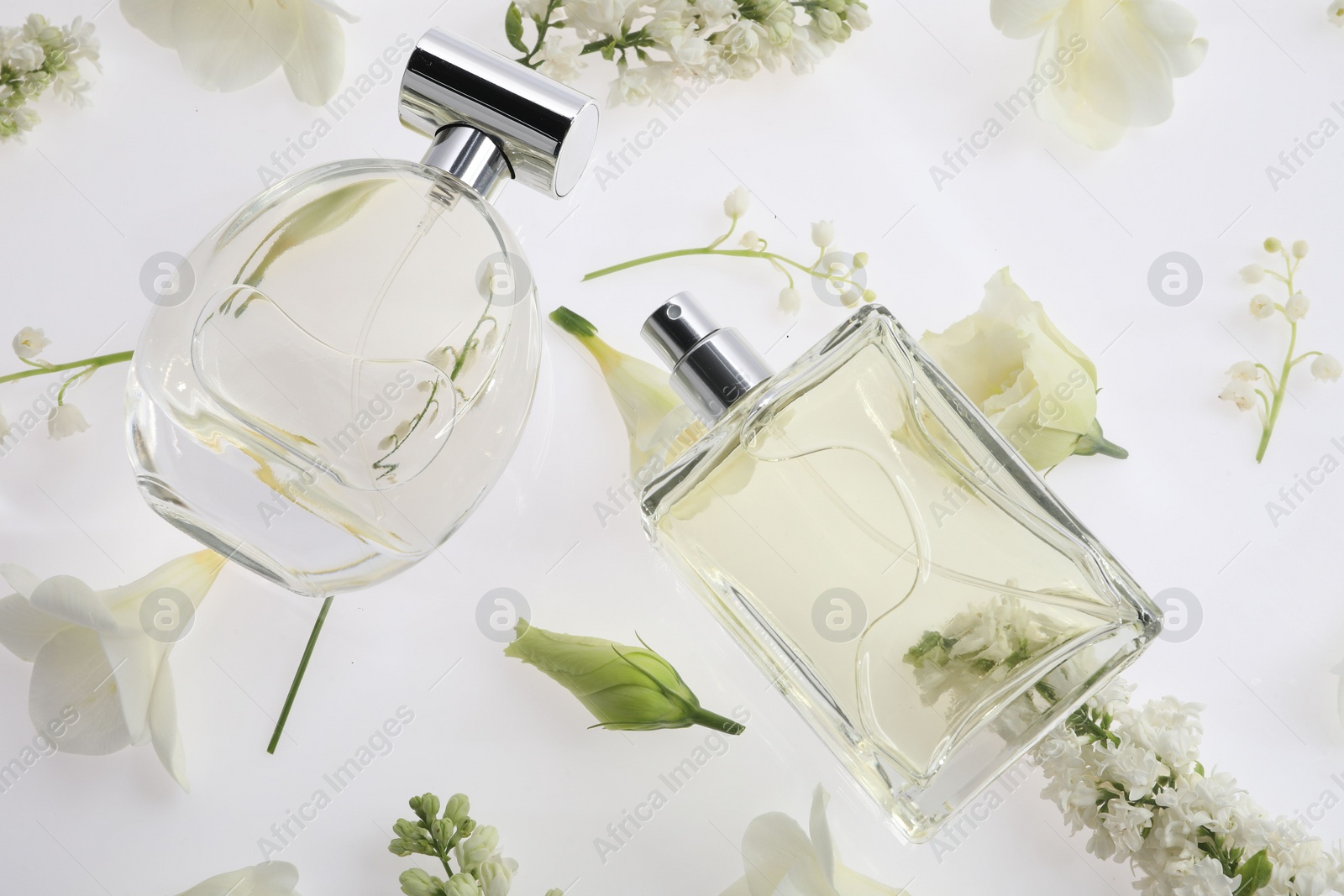 Photo of Luxury perfumes on spring floral decor, above view