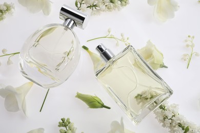 Photo of Luxury perfumes on spring floral decor, above view