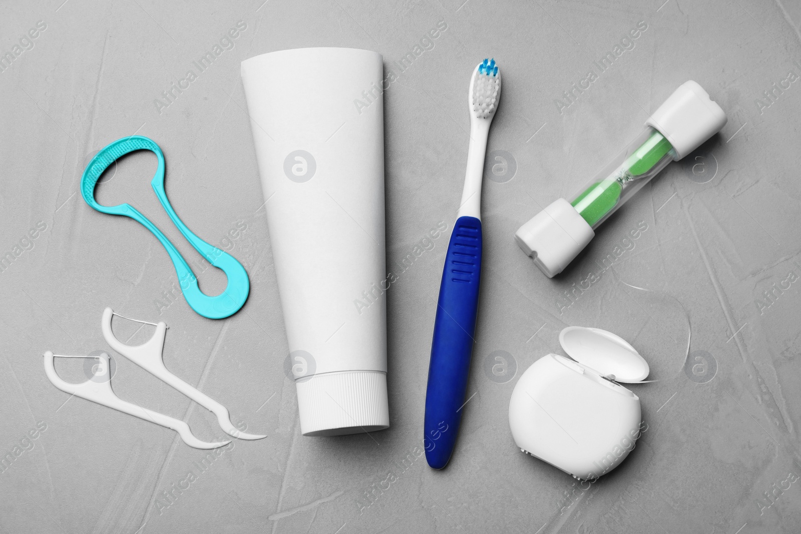 Photo of Flat lay composition with tongue cleaner and teeth care products on grey background