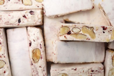 Photo of Pieces of delicious nougat as background, top view