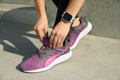 Woman wearing modern smart watch during training outdoors, closeup