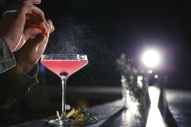 Photo of Barman making cosmopolitan martini cocktail at counter, closeup. Space for text