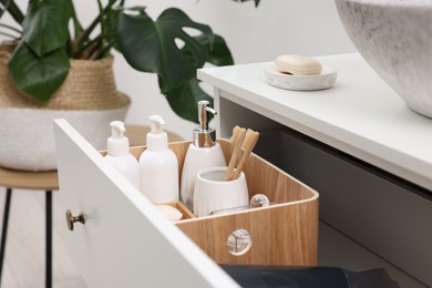 Different bath accessories and personal care products in drawer indoors