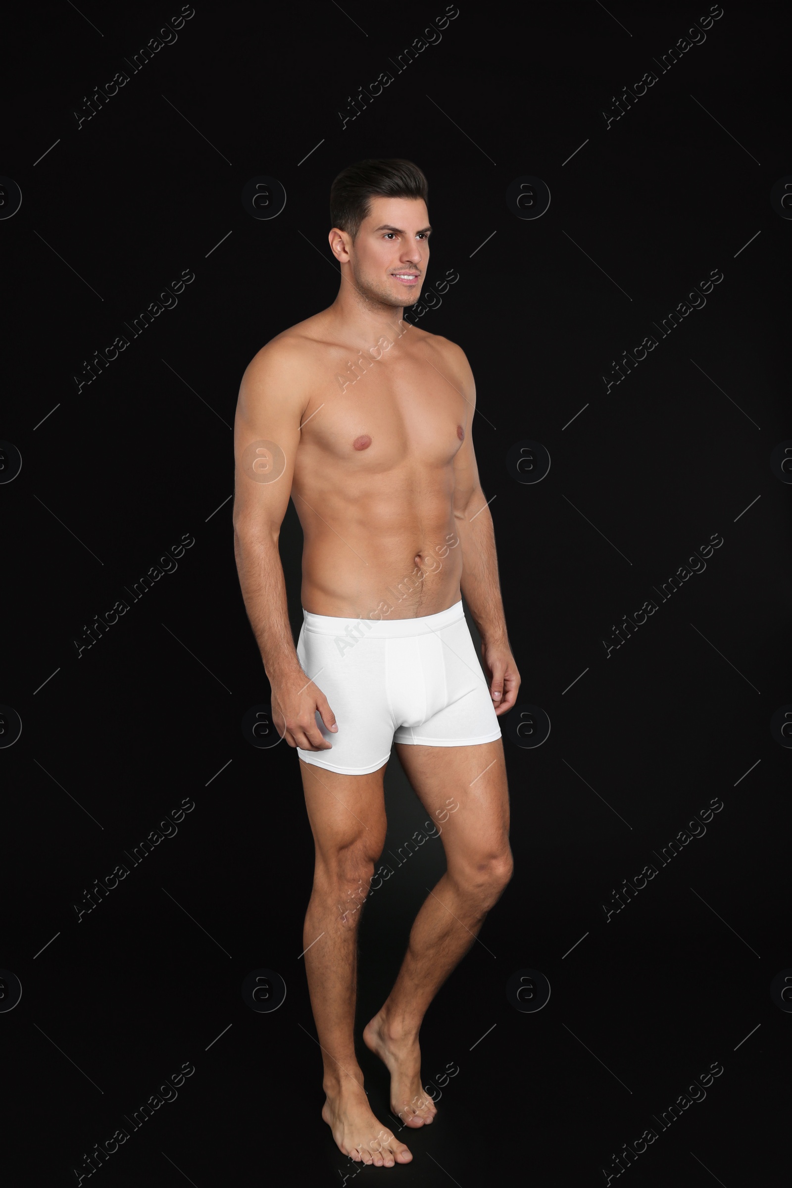 Photo of Handsome man in underwear on black background