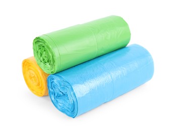 Photo of Rolls of colorful garbage bags isolated on white