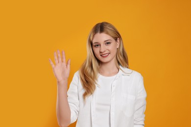 Photo of Happy woman giving high five on orange background