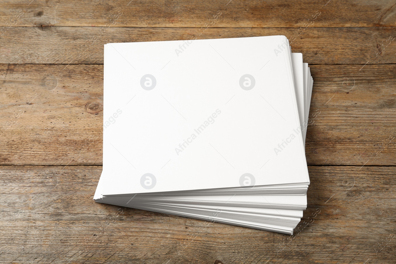 Photo of Stack of blank paper sheets for brochure on wooden background. Mock up