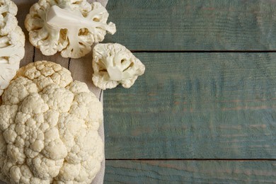 Photo of Fresh raw cauliflower on light blue wooden table, flat lay. Space for text