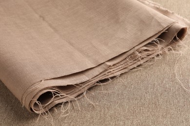 Photo of One folded light brown fabric on cloth, closeup