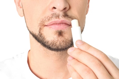 Photo of Man applying hygienic lip balm, on white background