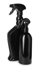 Photo of Black plastic spray bottles on white background