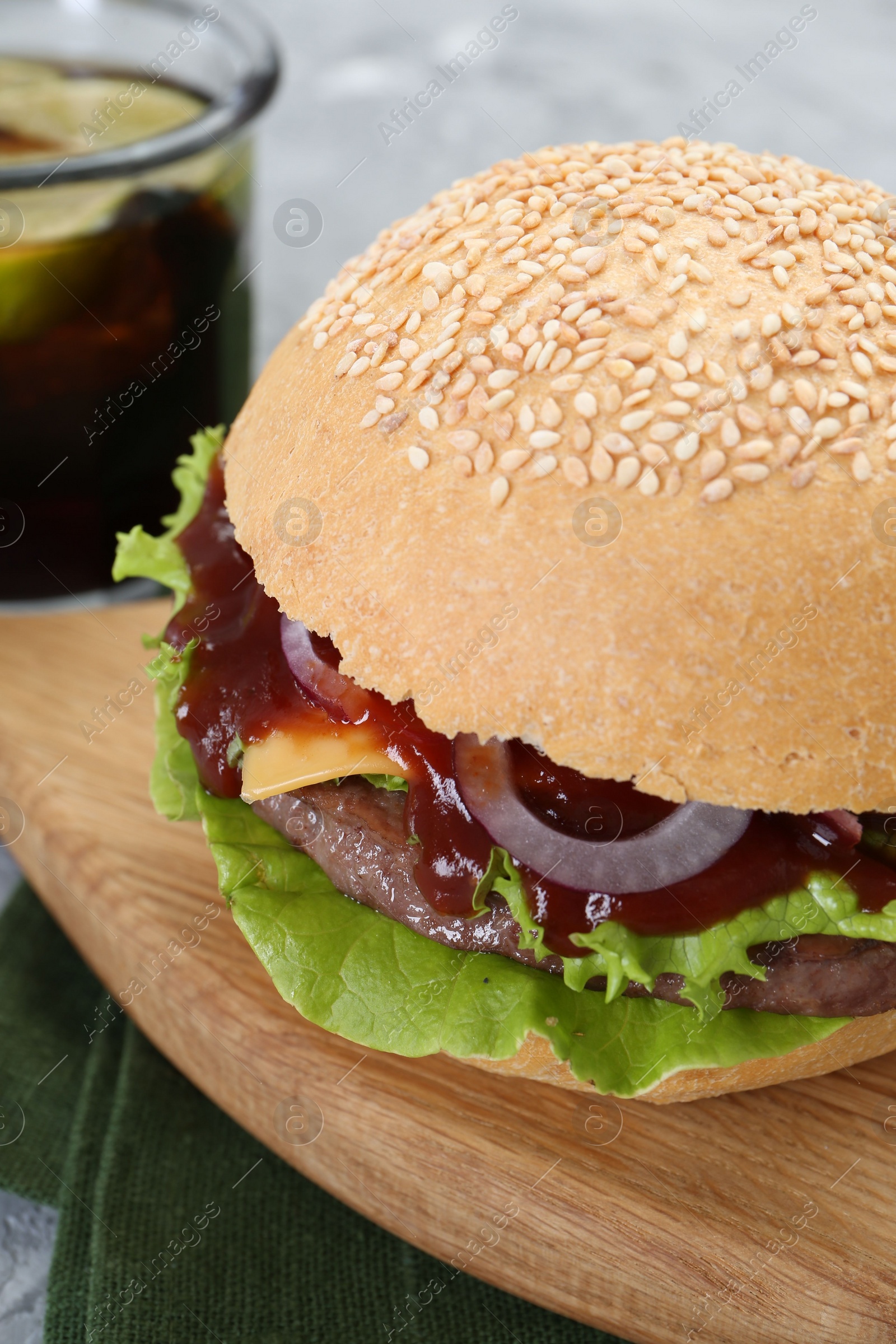 Photo of Board with delicious cheeseburger on table, closeup