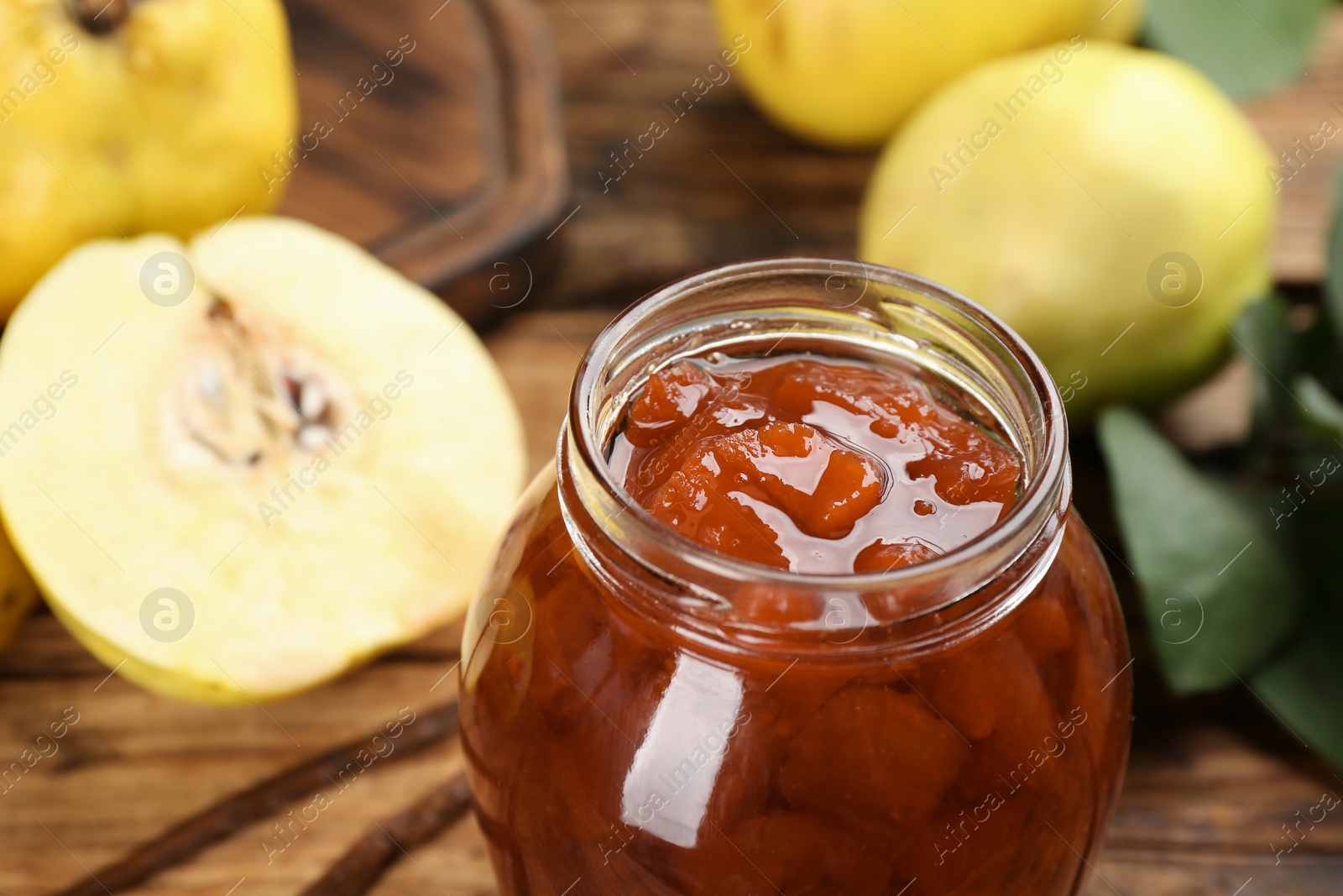 Photo of Delicious quince jam in jar on table, closeup