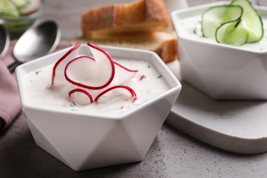 Delicious cold summer soup on grey table, closeup