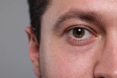 Closeup view of man with beautiful eyes on grey background