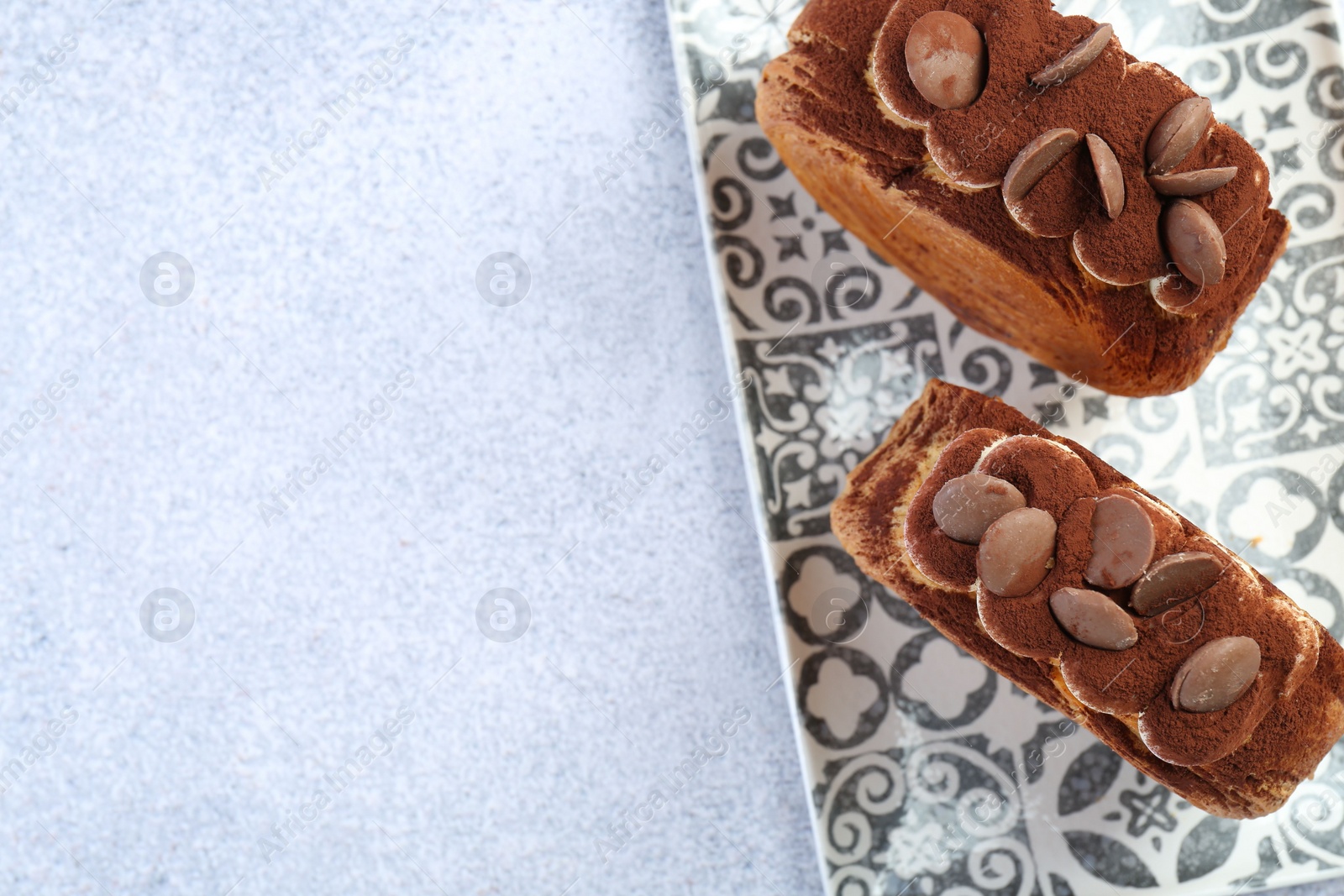 Photo of Tasty puff pastry. Supreme croissants with chocolate chips and cream on grey table, top view. Space for text