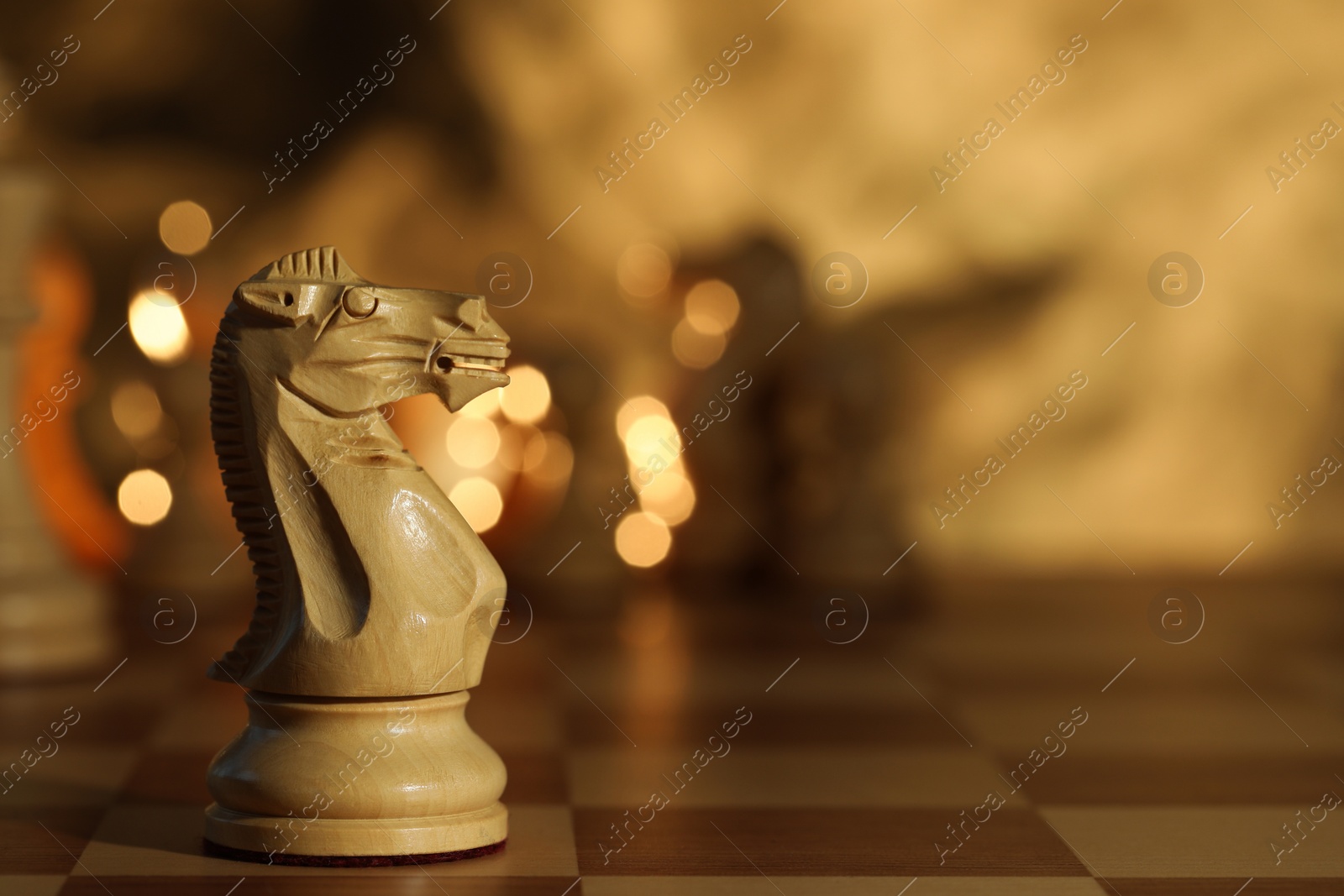 Photo of Wooden knight on chessboard, selective focus. Space for text