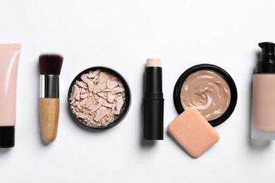 Foundation, beauty accessories and face powder on white background, flat lay