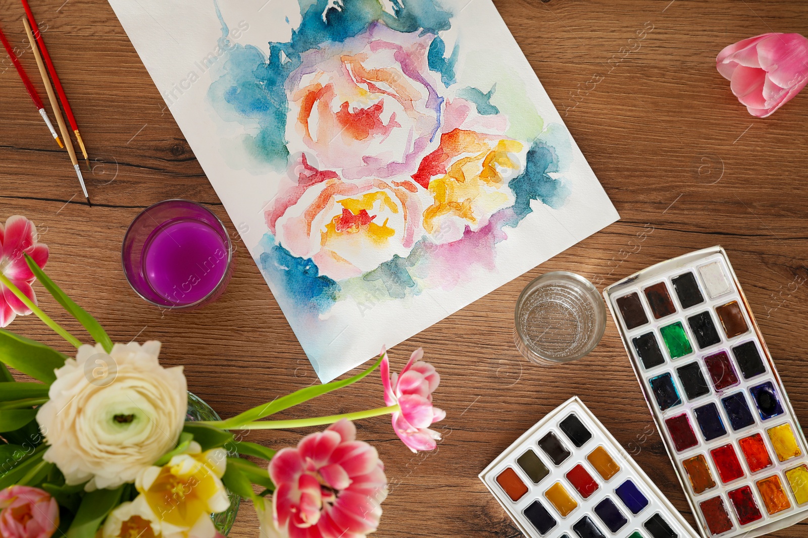 Photo of Flat lay composition with watercolor paints and floral picture on wooden table. Creative artwork