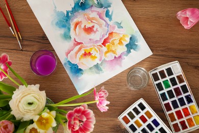Flat lay composition with watercolor paints and floral picture on wooden table. Creative artwork