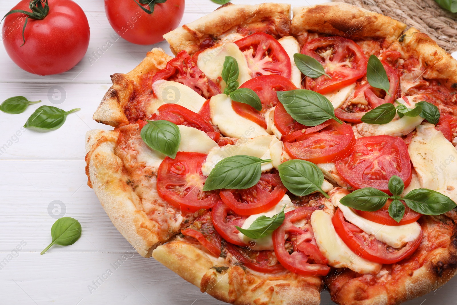 Photo of Delicious Caprese pizza on white wooden table, closeup