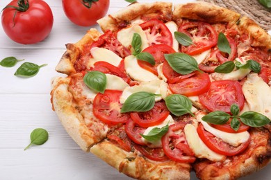 Photo of Delicious Caprese pizza on white wooden table, closeup