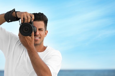 Photo of Photographer taking picture with professional camera near sea