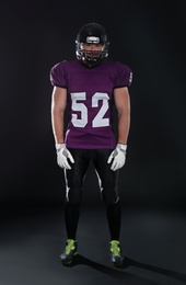 American football player wearing uniform on dark background