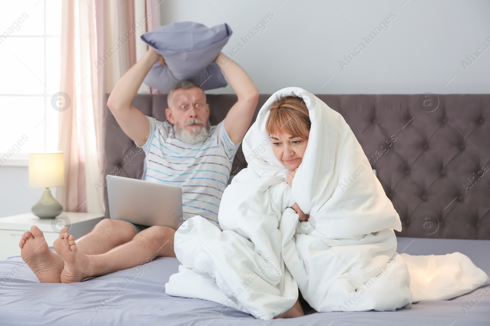 Photo of Mature couple with problem in relationship on bed at home