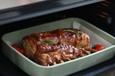 Photo of Delicious roasted ribs with tomatoes in oven