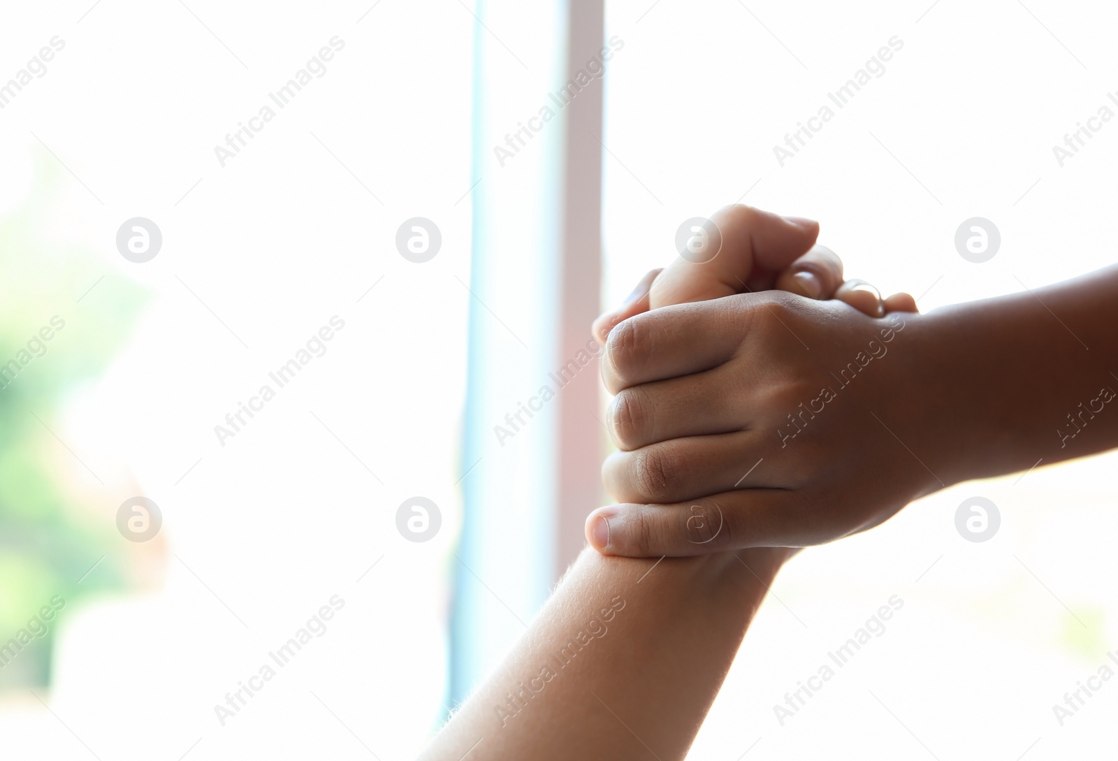 Photo of Children holding hands on blurred background, closeup. Unity concept