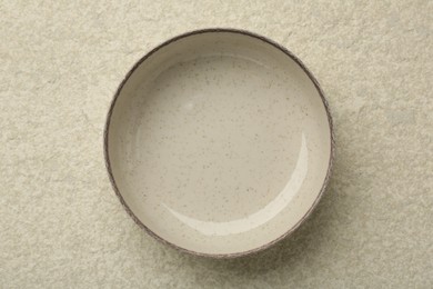 Photo of Beautiful ceramic bowl on beige table, top view