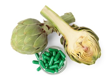 Photo of Fresh artichokes and pills isolated on white, top view