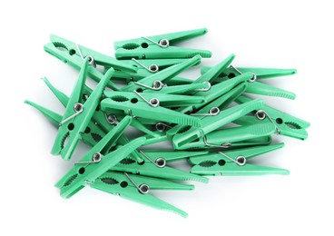 Green plastic clothespins on white background, top view