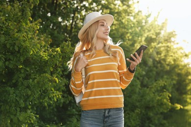 Portrait of happy young woman in park on spring day