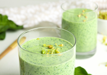 Photo of Green buckwheat smoothie on white table, closeup