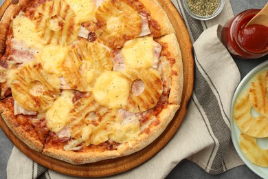 Delicious pineapple pizza and ingredients on table, flat lay