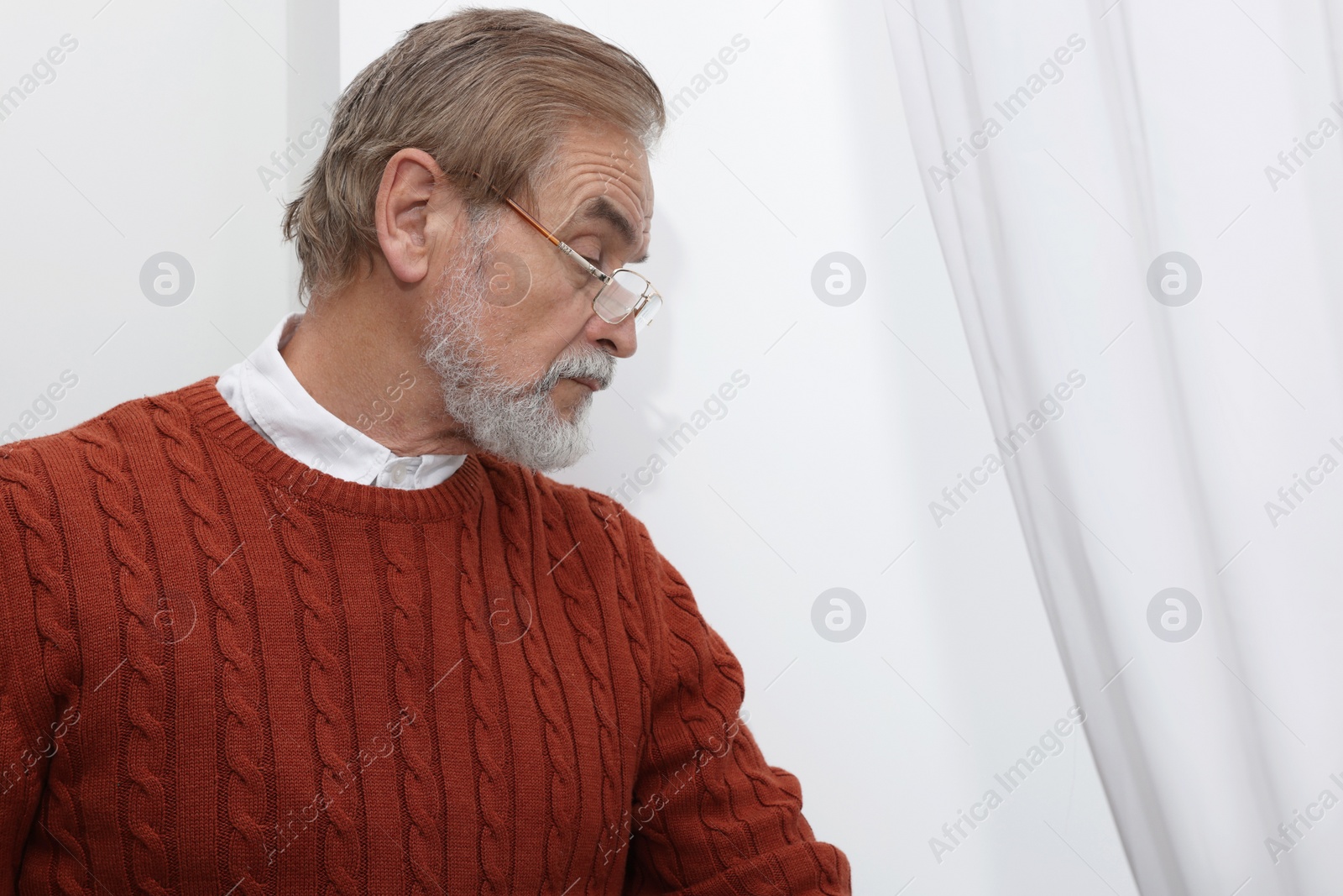 Photo of Upset senior man at home, space for text. Loneliness concept