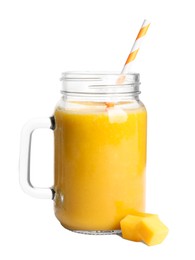 Mason jar of tasty mango smoothie and fruit slices on white background