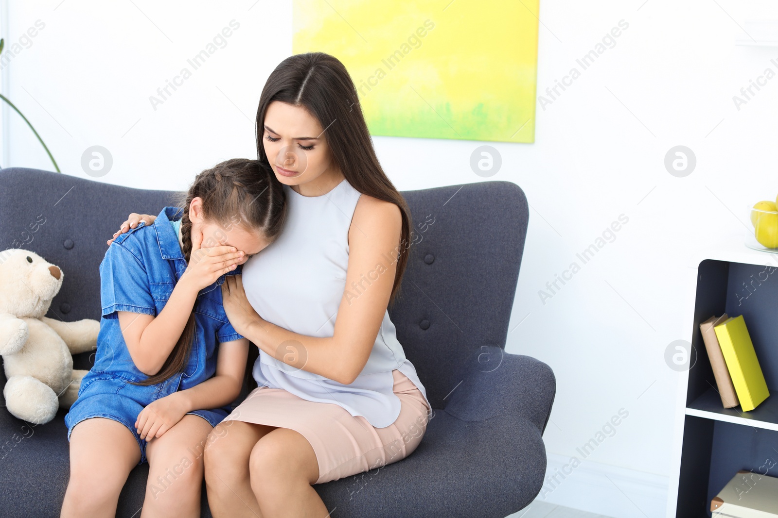 Photo of Child psychologist working with little girl in office
