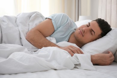 Photo of Man sleeping in bed with white linens at home