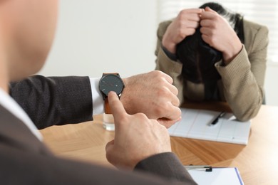 Businessman pointing on wrist watch while scolding employee for being late in office, closeup