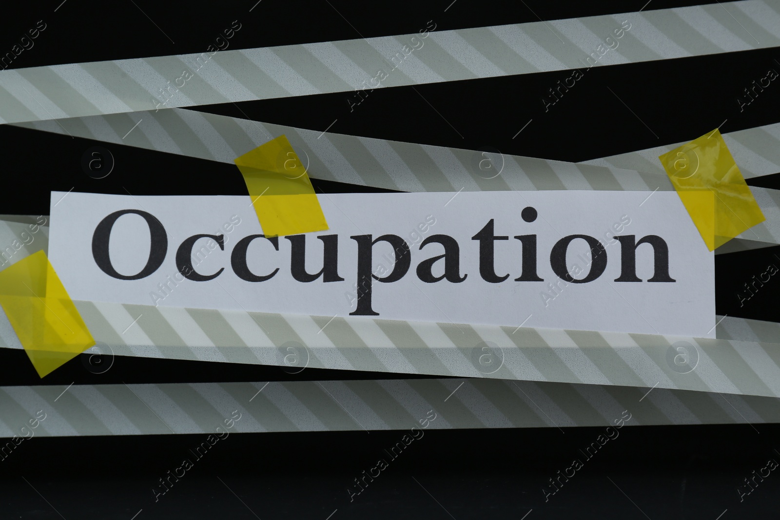 Photo of Word Occupation attached with yellow adhesive tape on black background