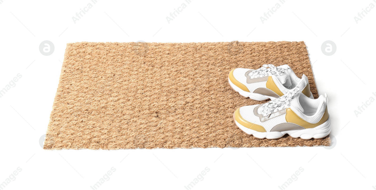 Photo of New clean doormat with shoes on white background