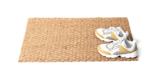 Photo of New clean doormat with shoes on white background