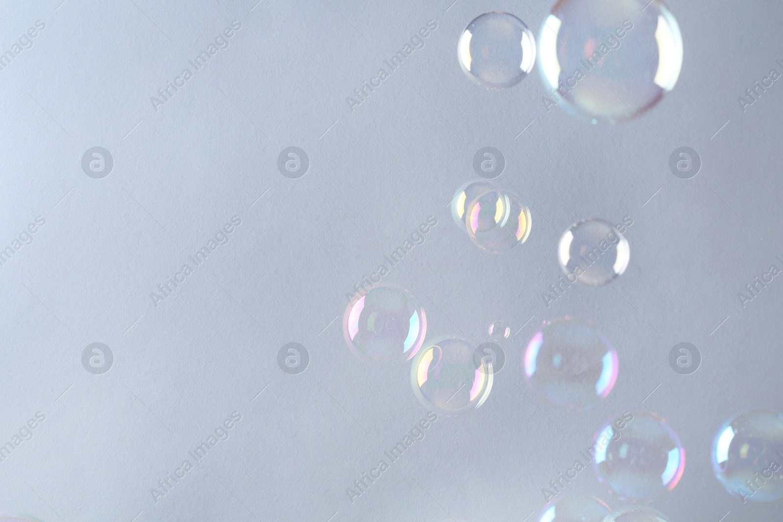 Photo of Beautiful transparent soap bubbles on gray background, space for text