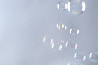 Beautiful transparent soap bubbles on gray background, space for text