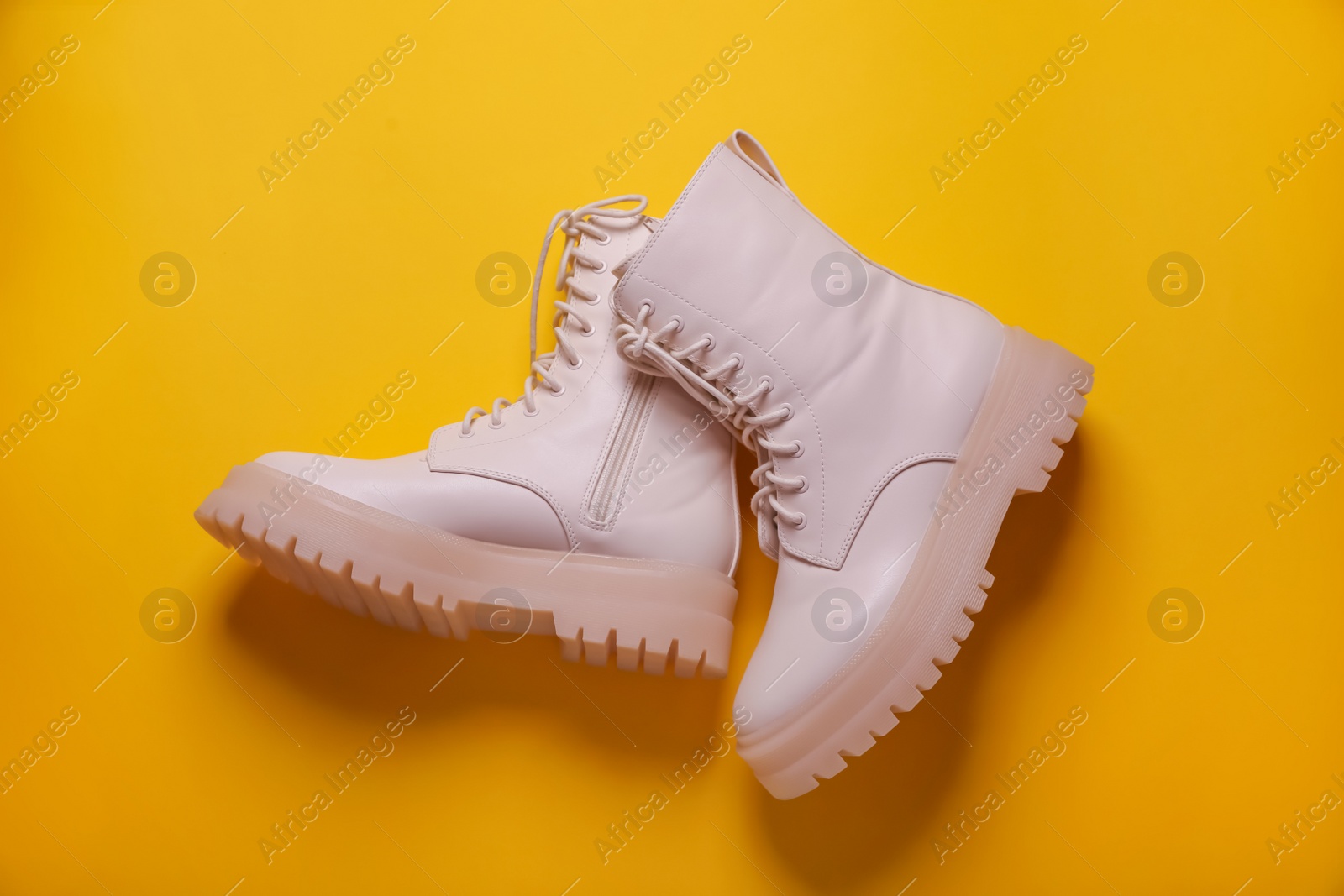 Photo of Pair of stylish shoes on yellow background, flat lay