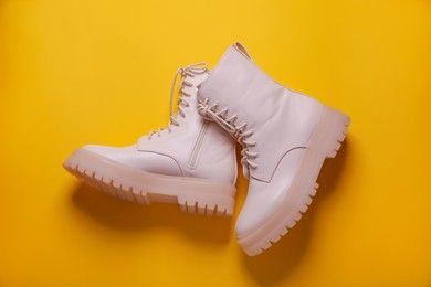 Photo of Pair of stylish shoes on yellow background, flat lay